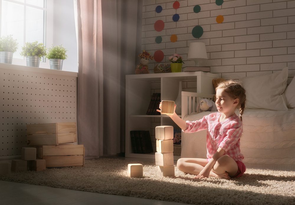 girl playing wooden building blocks