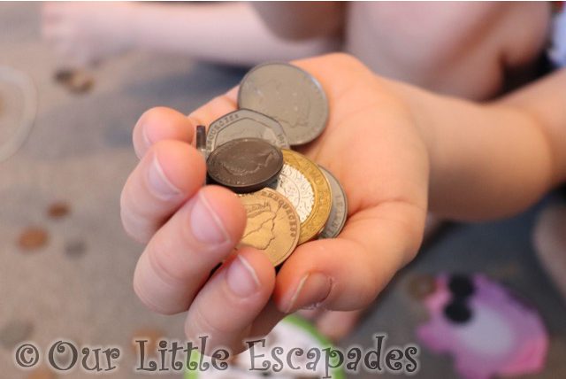 ethans hand holding realistic plastic coins learning resources money activity set