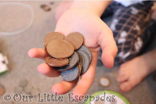 little es hand holding realistic plastic coins