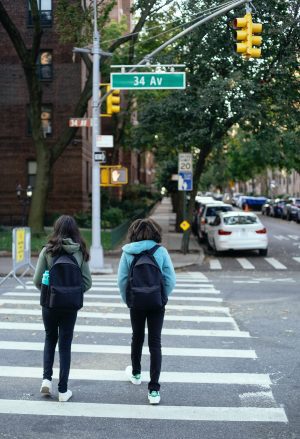 schoolgirls with backpacks crossing city road Safe On The School Run