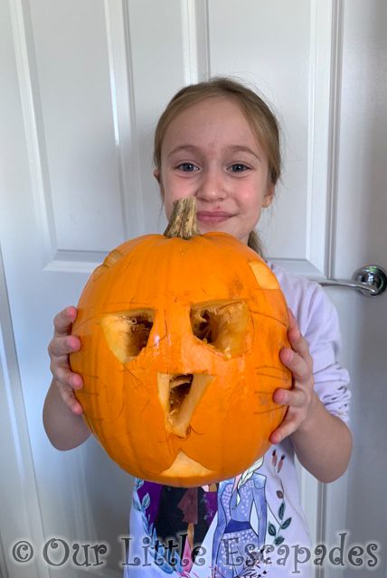 little e holding cat carved pumpkin
