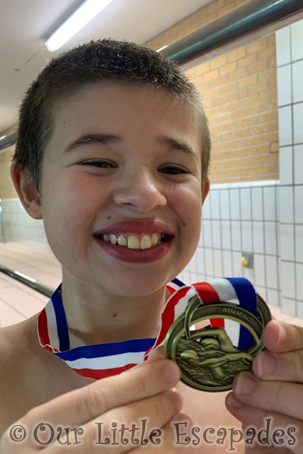smiling ethan holding gold medal christmas swimming gala