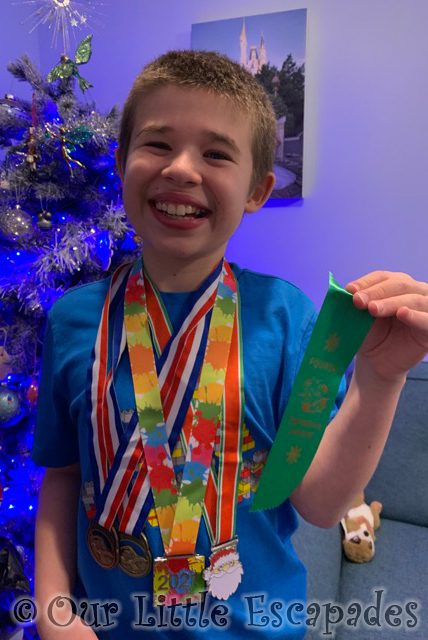 smiling ethan showing off christmas swimming gala medals