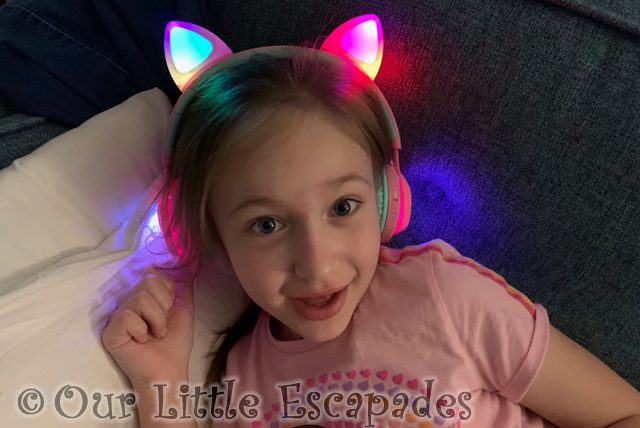 little e wearing flashing cat headphones sofa 2022 Week 6