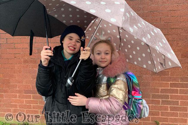 ethan little e standing under two unbrellas