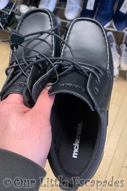 darrens hand holding black shoes