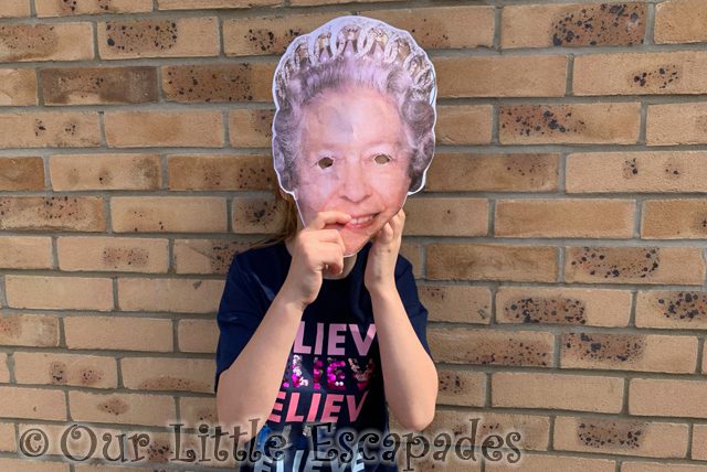 little e holding up queen elizabeth ii paper mask 2022 Week 21