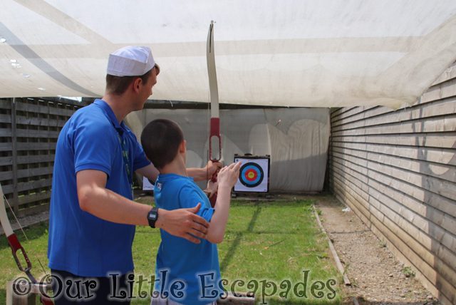 ethan pgl activity instructor helping archery pgl family holiday
