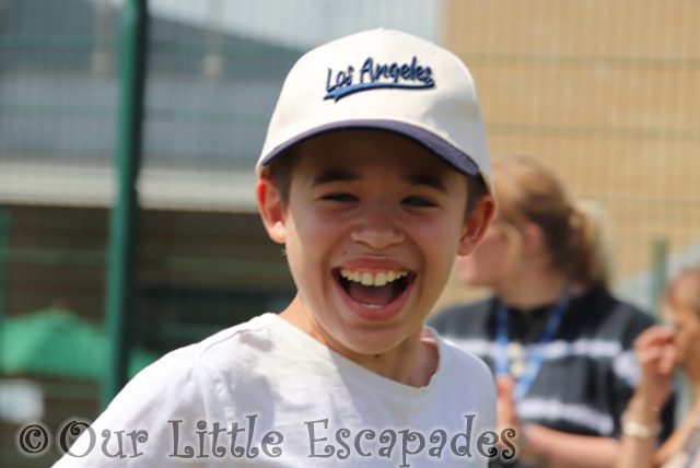 laughing ethan wearing baseball cap running sports day