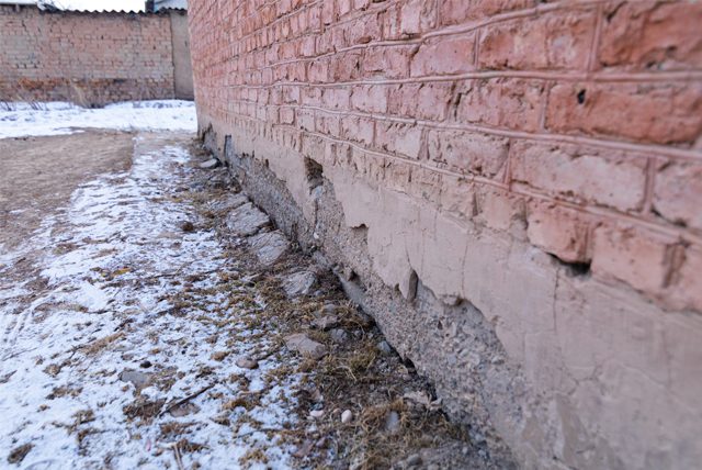 brick wall partially covered in snow storm